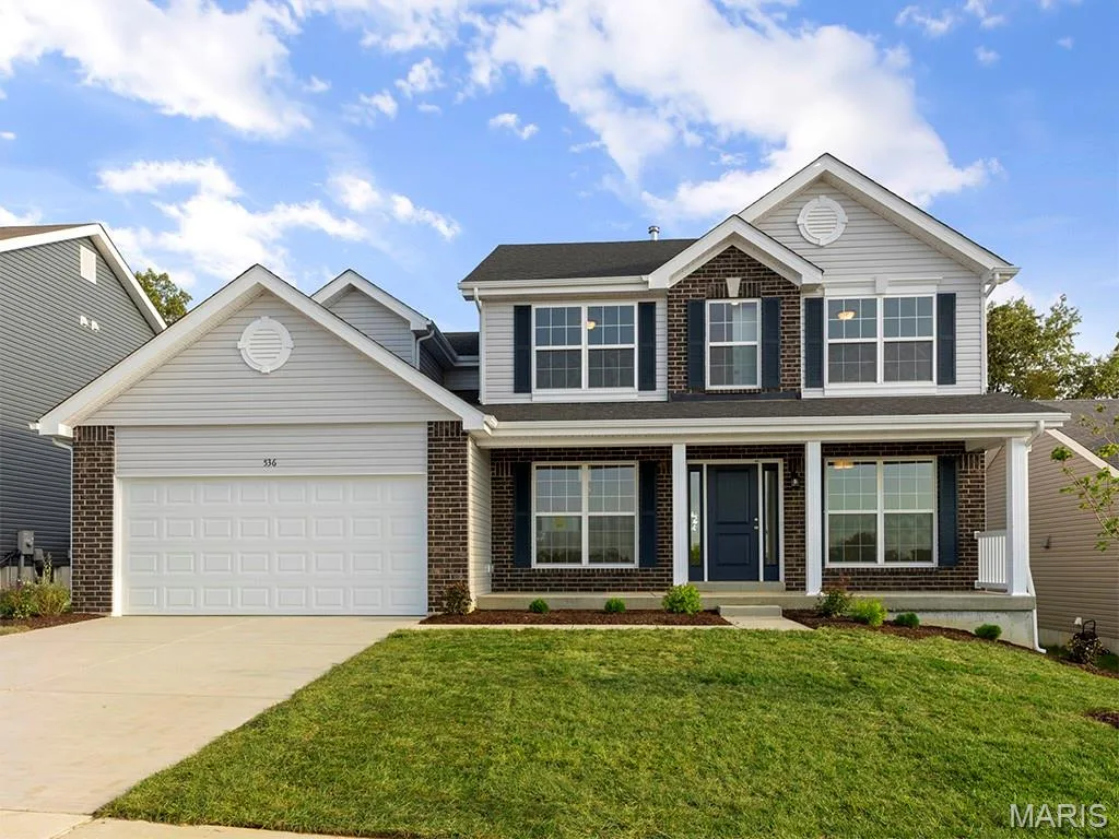 Traditional home with brick siding, driveway, a garage, and a front lawn — 2 Hermitage II at Harvest Estate, O'Fallon, MO 63368