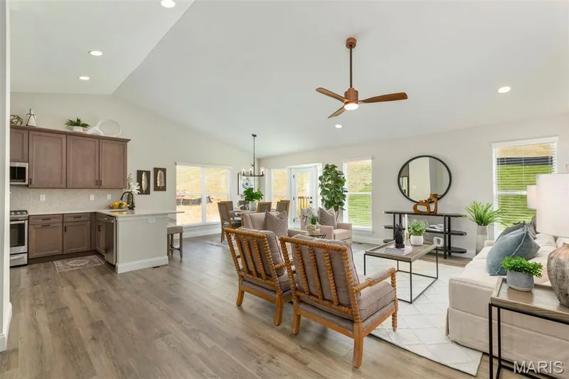 Living room with vaulted ceiling, a ceiling fan, light wood finished floors, recessed lighting, and a chandelier — 2 Hickory at Harvest Estates, O'Fallon, MO 63368