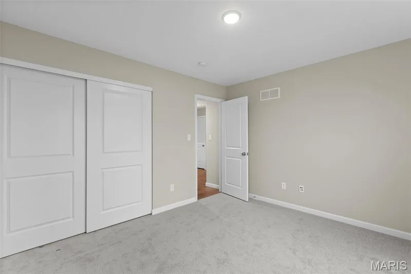 Unfurnished bedroom featuring carpet floors, baseboards, and a closet — 2 Maple Expanded at Harvest Est, O'Fallon, MO 63385