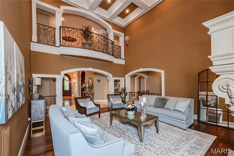In this view of the Great room, you are looking towards the Entry foyer. The archway on the right in this photo is open to the stair well leading to the lower level. Take note of the coffered ceiling with recessed lighting. — 4 Slate River Way, Wentzville, MO 63385