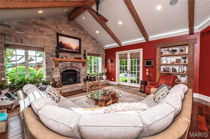The Hearth room is adjacent to the Kitchen/Breakfast room & some features are a stunning gas, fireplace, cathedral ceiling with reclaimed beams, indirect & recessed lighting & the French doors lead a covered porch — 4 Slate River Way, Wentzville, MO 63385