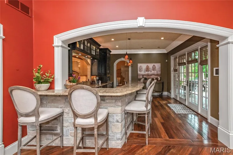 Here we move from the Hearth Room into the Coffee Bar room. The French doors lead to the covered back porch, patio &  swimming pool — 4 Slate River Way, Wentzville, MO 63385