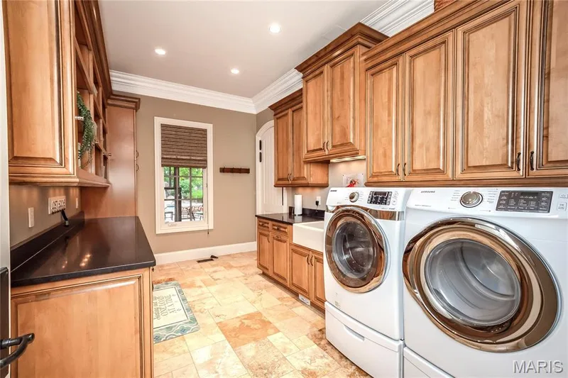 This is one of two main floor laundry rooms. It is located near the bedrooms & has a dressing room & en-suite full bath that can also be accessed from the covered back porch, patio & swimming pool area — 4 Slate River Way, Wentzville, MO 63385