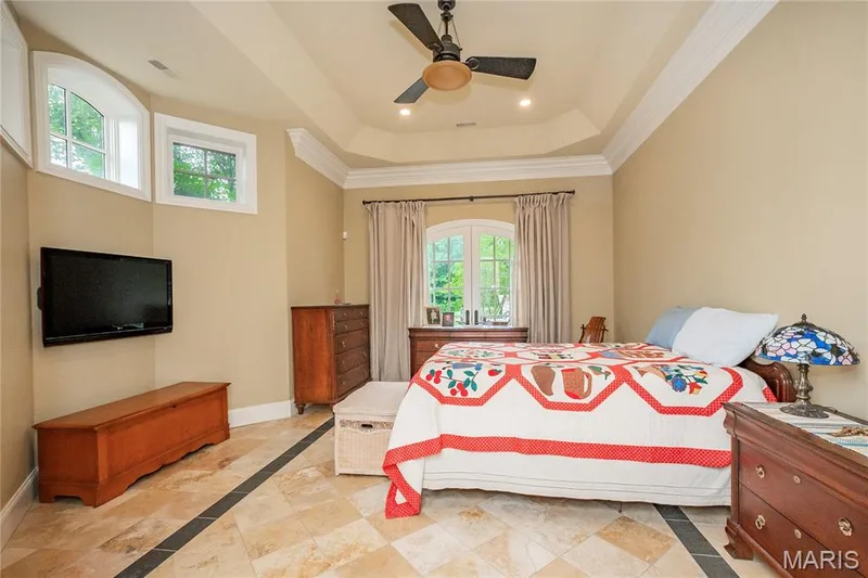 Lower level guest room with en-suite full bath & French doors which lead to  a large patio which is adjacent to the fire pit and 3 waterfalls — 4 Slate River Way, Wentzville, MO 63385