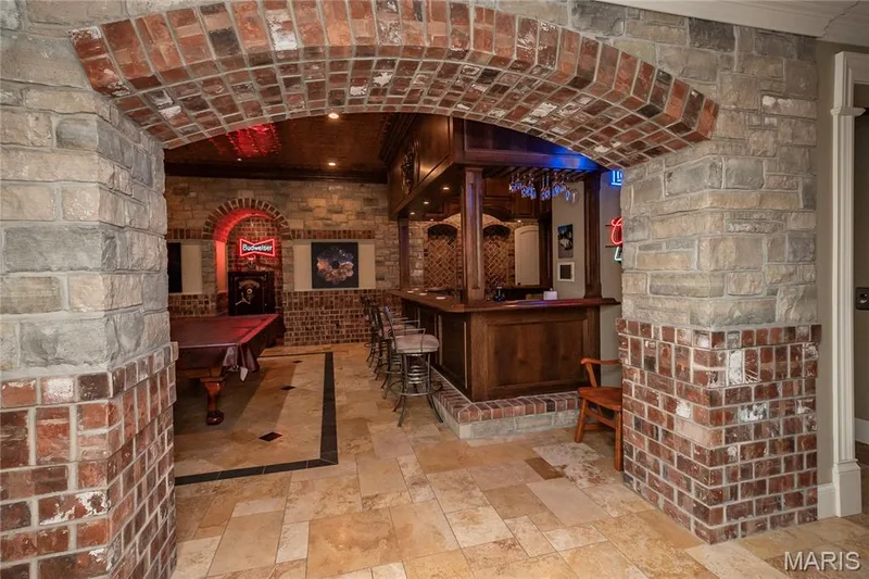 Now let's head to the lower level. This photo is a first look at the Bar/Billiard room. The stonework in this lower level is impressive — 4 Slate River Way, Wentzville, MO 63385