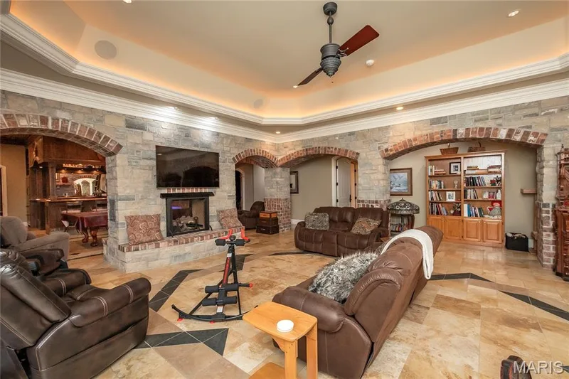 And now a couple of shots of the family room again featuring a tray ceiling with indirect & recessed lighting and a polished natural stone floor with slate inlay — 4 Slate River Way, Wentzville, MO 63385