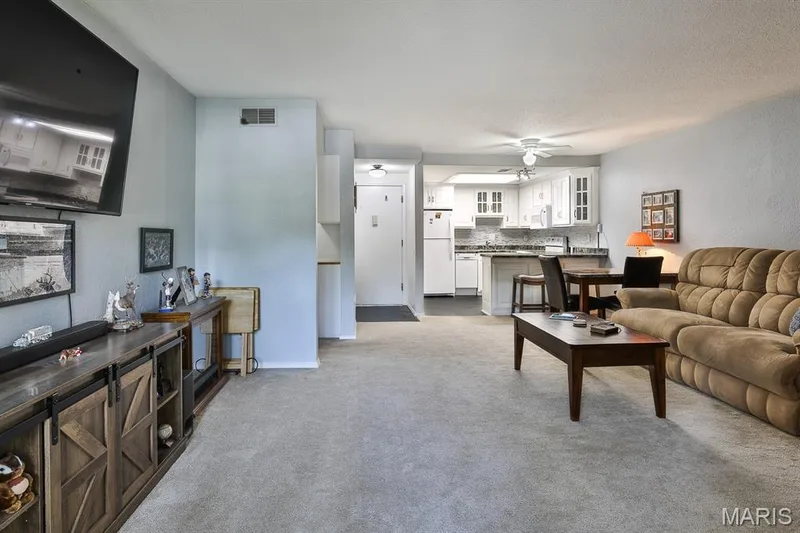 Living area with a ceiling fan and carpet — 1380 Heritage Landing #206, St Charles, MO 63303