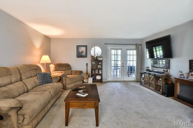 Living area featuring carpet flooring and french doors — 1380 Heritage Landing #206, St Charles, MO 63303