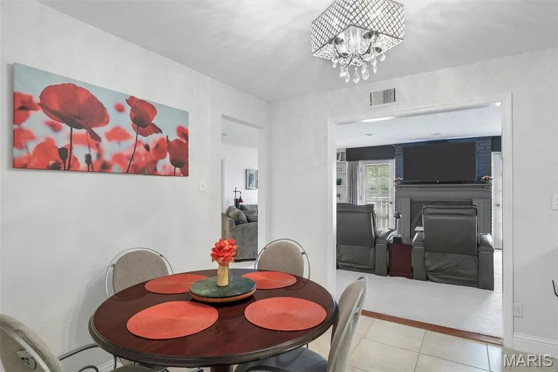 Dining space featuring a fireplace, tile patterned floors, and a chandelier — 1511 Hampton Hall Drive #19 & 20, Chesterfield, MO 63017