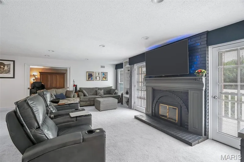 Carpeted living area featuring a textured ceiling and a fireplace — 1511 Hampton Hall Drive #19 & 20, Chesterfield, MO 63017