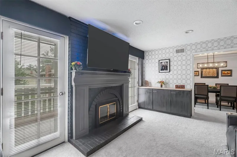 Living area with wallpapered walls, a textured ceiling, light carpet, and a chandelier — 1511 Hampton Hall Drive #19 & 20, Chesterfield, MO 63017