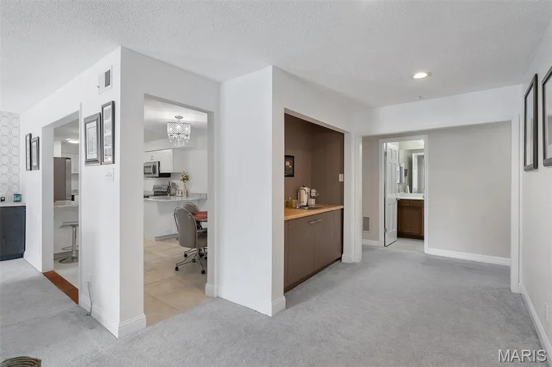 Hallway featuring light colored carpet, a textured ceiling, a chandelier, and recessed lighting — 1511 Hampton Hall Drive #19 & 20, Chesterfield, MO 63017