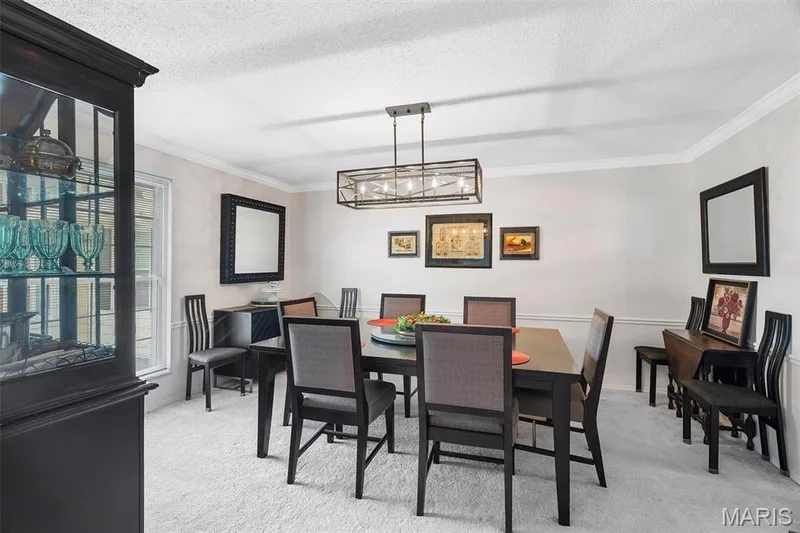 Dining space featuring ornamental molding, light carpet, and a textured ceiling — 1511 Hampton Hall Drive #19 & 20, Chesterfield, MO 63017