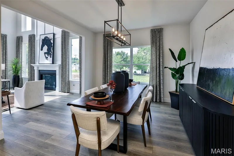 Dining area with a chandelier, wood finished floors, and a glass covered fireplace — 0 Braxton @ Montage at Hawk Ridge, Lake St. Louis, MO 63367