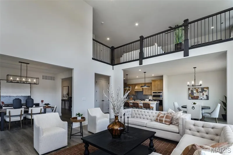 Living room featuring a chandelier, a towering ceiling, recessed lighting, and dark wood-style floors — 0 Braxton @ Montage at Hawk Ridge, Lake St. Louis, MO 63367