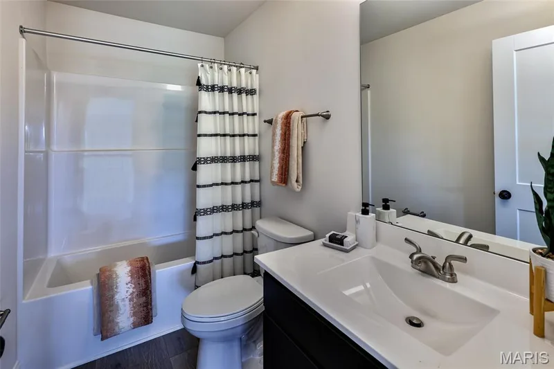 Bathroom with shower / bath combination with curtain, vanity, and dark wood-style flooring — 0 Braxton @ Montage at Hawk Ridge, Lake St. Louis, MO 63367