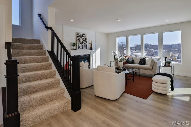 Living room featuring healthy amount of natural light, light wood-style flooring, stairway, recessed lighting, and a glass covered fireplace — 0 Bridgeport - Montage at Hawk Ridge, Lake St. Louis, MO 63367