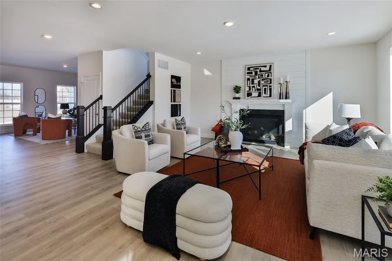 Living room featuring a glass covered fireplace, recessed lighting, stairs, and wood finished floors — 0 Bridgeport - Montage at Hawk Ridge, Lake St. Louis, MO 63367