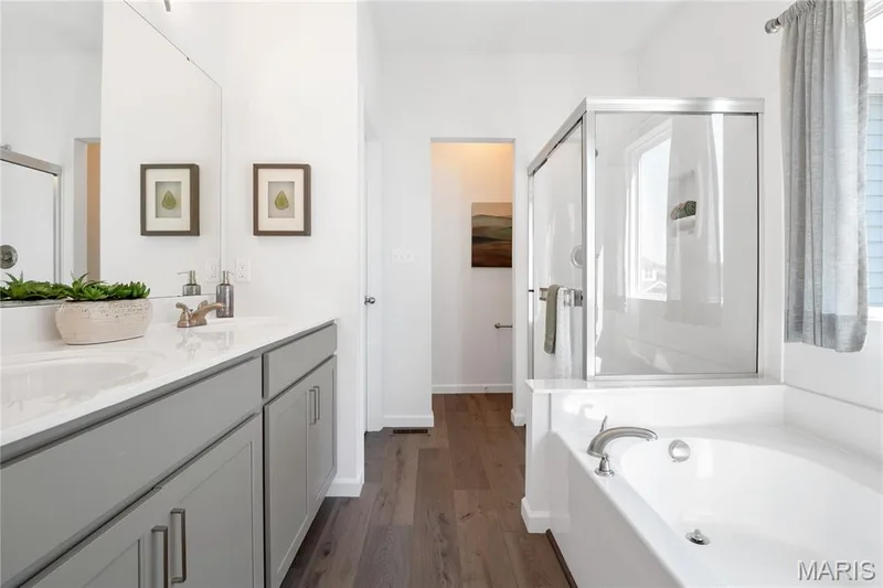 Bathroom featuring a stall shower, double vanity, a garden tub, dark wood finished floors, and healthy amount of natural light — 0 Chesapeake @ Montage at Hawk Ridge, Lake St. Louis, MO 63367