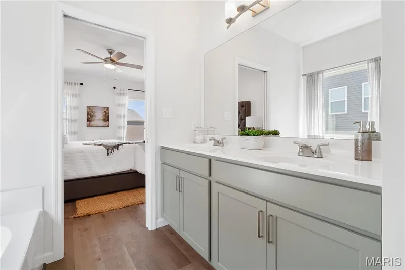 Bathroom with ensuite bath, double vanity, dark wood-style floors, and healthy amount of natural light — 0 Chesapeake @ Montage at Hawk Ridge, Lake St. Louis, MO 63367