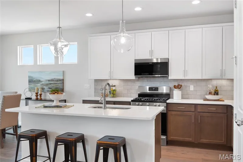 Kitchen featuring white cabinets, appliances with stainless steel finishes, a kitchen island with sink, light wood finished floors, and recessed lighting — 0 Chesapeake @ Montage at Hawk Ridge, Lake St. Louis, MO 63367