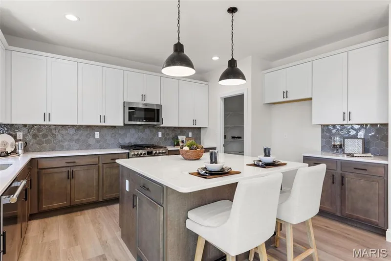 Kitchen with backsplash, a center island, a kitchen bar, light wood-style flooring, and recessed lighting — 0 Lancaster @ Montage at Hawk Ridge, Lake St. Louis, MO 63367