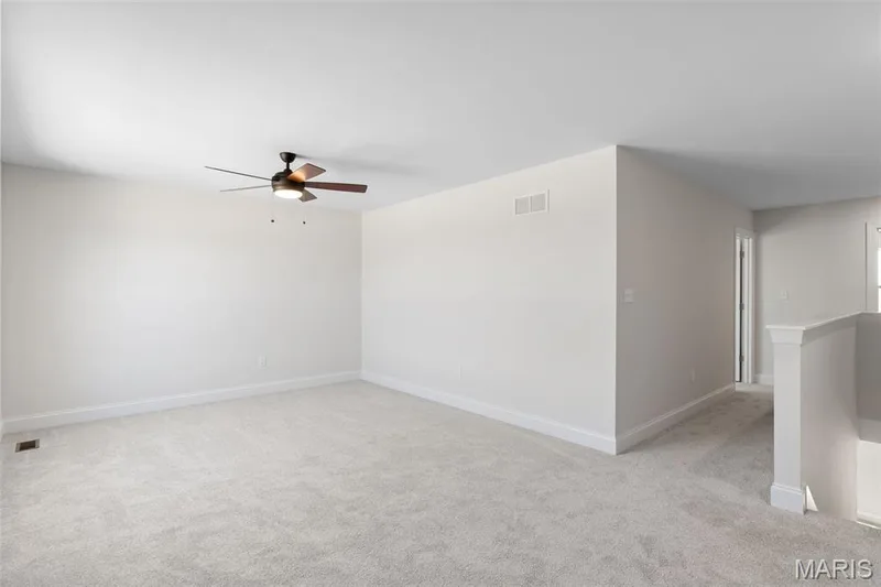 Unfurnished room featuring light colored carpet and a ceiling fan — 0 Lancaster @ Montage at Hawk Ridge, Lake St. Louis, MO 63367