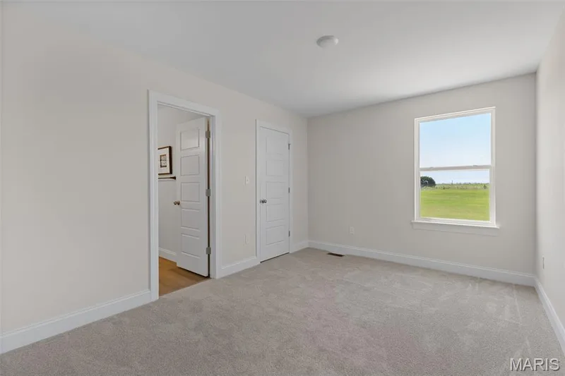 Unfurnished bedroom with light carpet and a water view — 0 Lancaster @ Montage at Hawk Ridge, Lake St. Louis, MO 63367