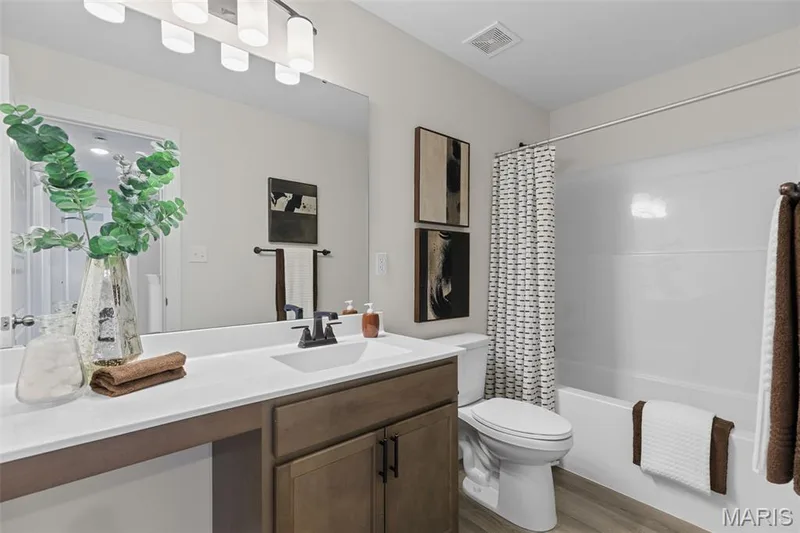 Bathroom with vanity, shower / bath combo, and light wood-style flooring — 0 Lancaster @ Montage at Hawk Ridge, Lake St. Louis, MO 63367