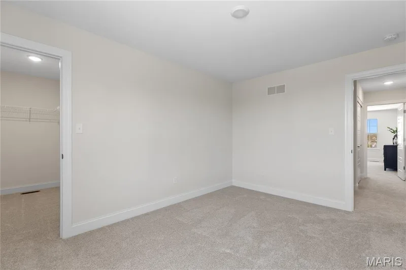 Unfurnished bedroom featuring light carpet, a walk in closet, and recessed lighting — 0 Lancaster @ Montage at Hawk Ridge, Lake St. Louis, MO 63367
