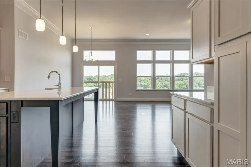 Kitchen featuring ornamental molding, pendant lighting, dark wood-type flooring, a chandelier, and a kitchen breakfast bar — 0 Pierce @ Montage at Hawk Ridge, Lake St. Louis, MO 63367