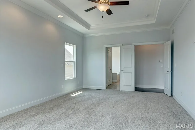 Unfurnished bedroom with a raised ceiling, light carpet, crown molding, and ceiling fan — 0 Pierce @ Montage at Hawk Ridge, Lake St. Louis, MO 63367