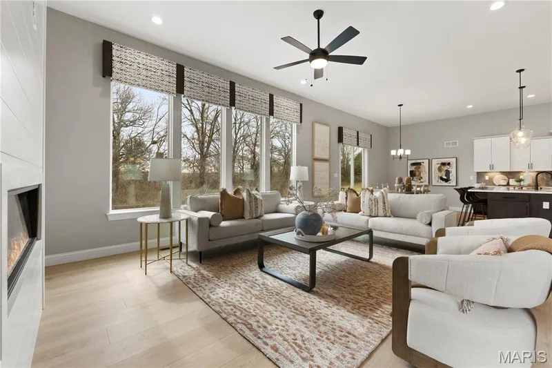 Living room featuring a large fireplace, recessed lighting, light wood finished floors, a ceiling fan, and a chandelier — 0 Sierra @ Montage at Hawk Ridge, Lake St. Louis, MO 63367