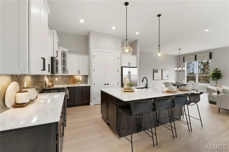 Kitchen with light stone countertops, tasteful backsplash, decorative light fixtures, glass insert cabinets, and stainless steel appliances — 0 Sierra @ Montage at Hawk Ridge, Lake St. Louis, MO 63367