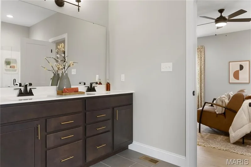 Ensuite bathroom featuring double vanity, ceiling fan, and dark tile patterned flooring — 0 Sierra @ Montage at Hawk Ridge, Lake St. Louis, MO 63367