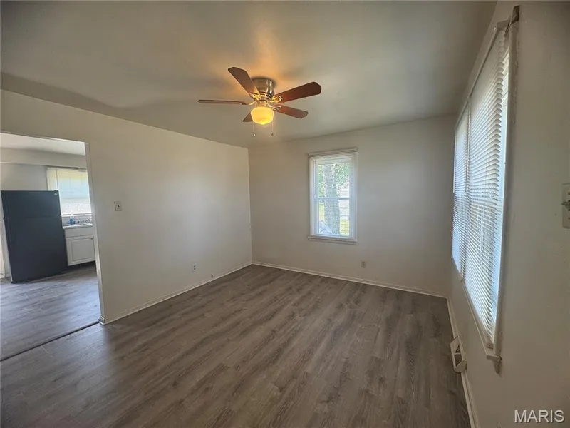 Unfurnished bedroom featuring freestanding refrigerator, dark wood-style floors, and a ceiling fan — 2816 Mulberry Lane, St Charles, MO 63303