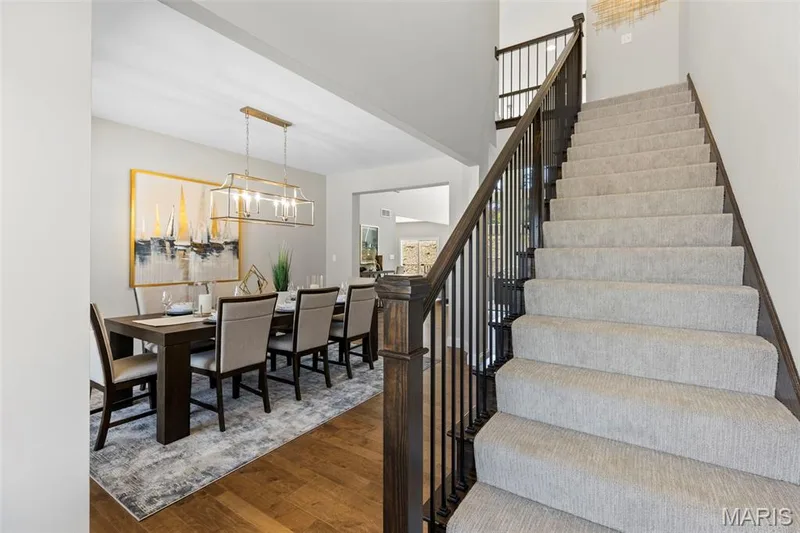 Stairs with wood finished floors and a chandelier — 2 Pin Oak at Hawk Ridge Estate, Lake St. Louis, MO 63367