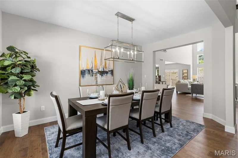 Dining area with dark wood-style flooring and a chandelier — 2 Pin Oak at Hawk Ridge Estate, Lake St. Louis, MO 63367