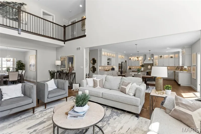 Living room featuring a chandelier, a towering ceiling, wood finished floors, and recessed lighting — 2 Pin Oak at Hawk Ridge Estate, Lake St. Louis, MO 63367