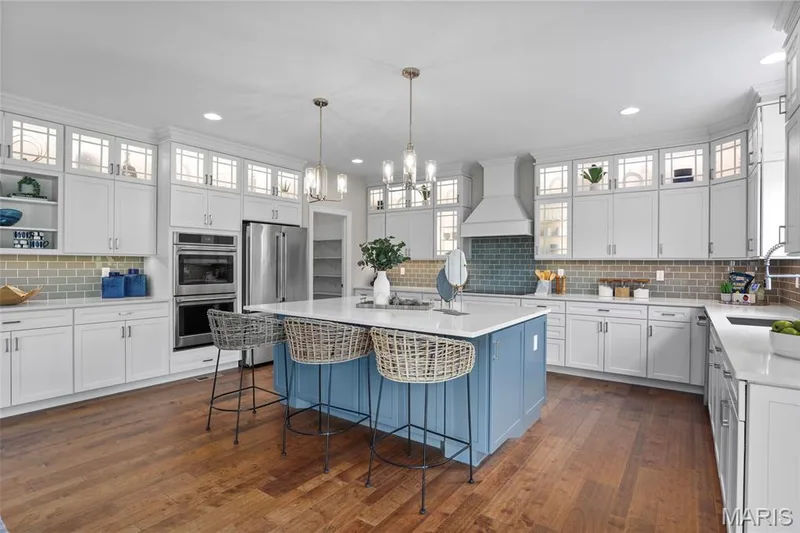 Kitchen featuring glass insert cabinets, backsplash, stainless steel appliances, recessed lighting, and ornamental molding — 2 Pin Oak at Hawk Ridge Estate, Lake St. Louis, MO 63367