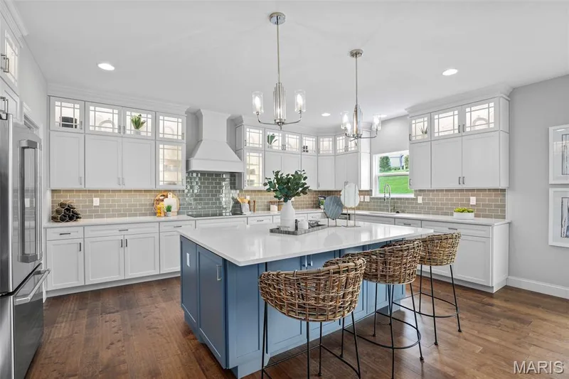 Kitchen with blue cabinetry, white cabinets, backsplash, high quality fridge, and recessed lighting — 2 Pin Oak at Hawk Ridge Estate, Lake St. Louis, MO 63367