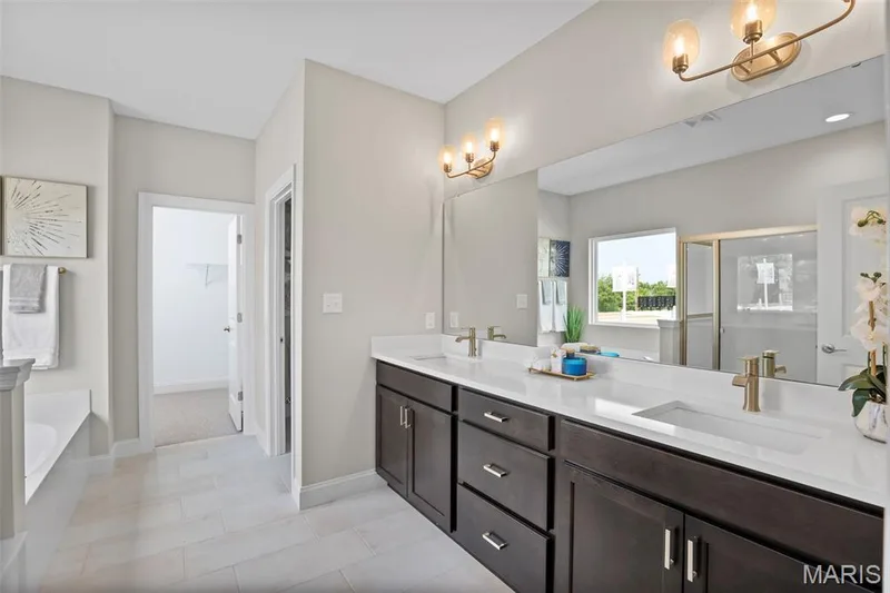 Bathroom with a chandelier, a stall shower, double vanity, and a garden tub — 2 Pin Oak at Hawk Ridge Estate, Lake St. Louis, MO 63367