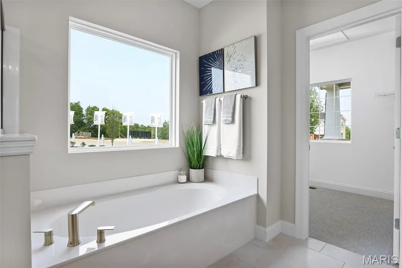 Bathroom with light tile patterned floors and a garden tub — 2 Pin Oak at Hawk Ridge Estate, Lake St. Louis, MO 63367