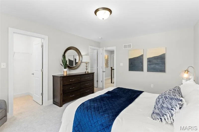 Bedroom with light colored carpet and a walk in closet — 2 Pin Oak at Hawk Ridge Estate, Lake St. Louis, MO 63367