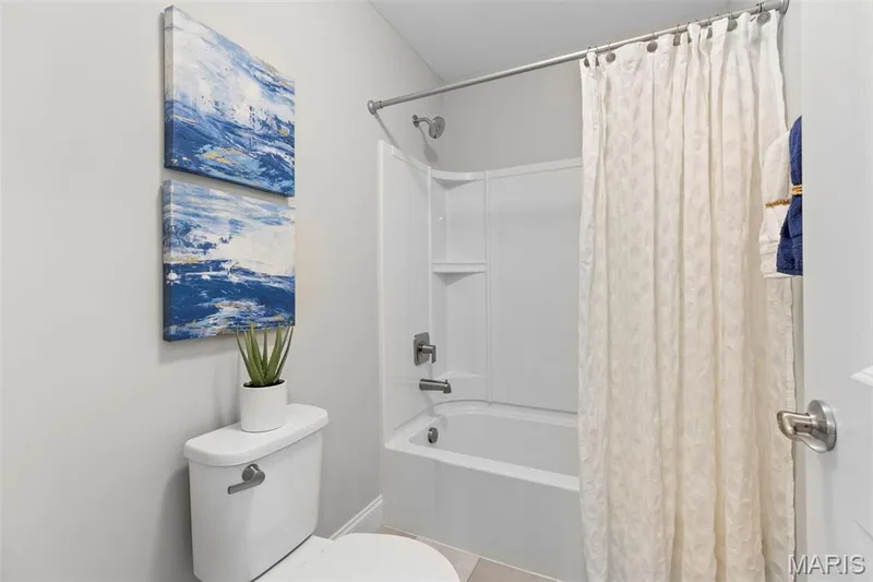 Bathroom featuring shower / tub combo and tile patterned flooring — 2 Pin Oak at Hawk Ridge Estate, Lake St. Louis, MO 63367