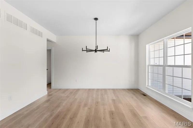 Unfurnished dining area featuring light wood-type flooring and a chandelier — 2 Sequoia at Hawk Ridge Estate, Lake St. Louis, MO 63367