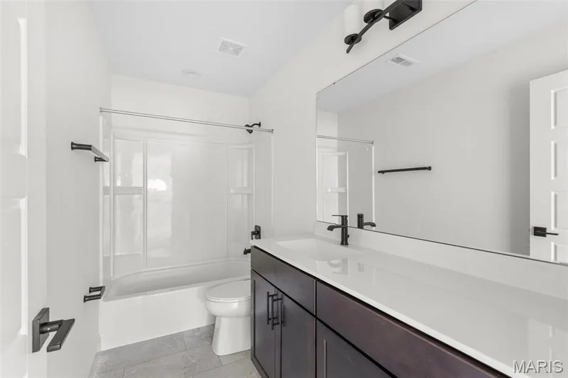 Bathroom with washtub / shower combination, vanity, and light tile patterned flooring — 2 Sequoia at Hawk Ridge Estate, Lake St. Louis, MO 63367