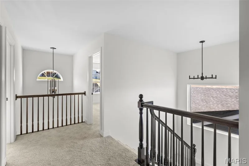 Corridor featuring an upstairs landing, light colored carpet, and a chandelier — 2 Sequoia at Hawk Ridge Estate, Lake St. Louis, MO 63367