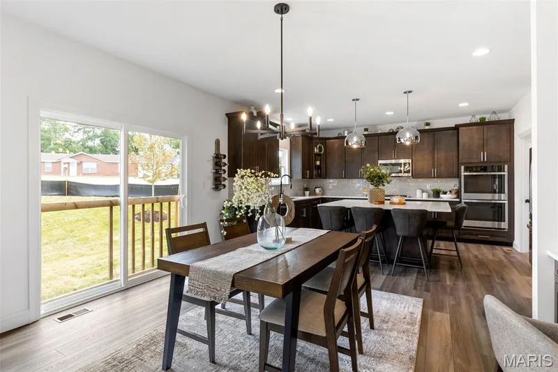 Dining room featuring dark wood-style flooring, recessed lighting, and a chandelier — 2 Nottingham at Hawk Ridge, Lake St. Louis, MO 63367