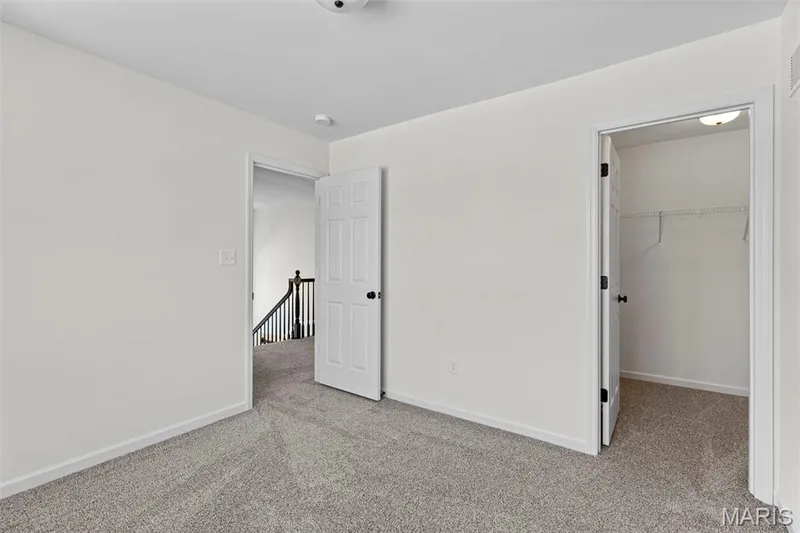 Unfurnished bedroom featuring a walk in closet and light colored carpet — 563 Edison Way, Wentzville, MO 63385